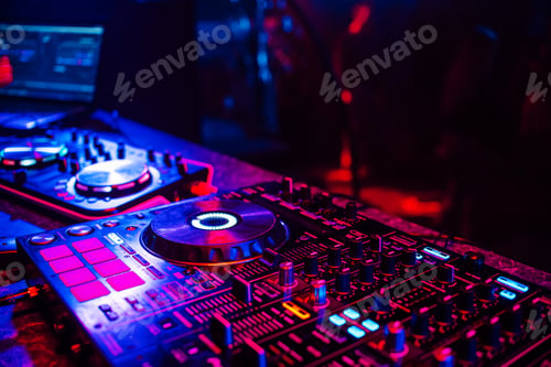 Preview: DJ console for mixing music with blurry people dancing at a nightclub party