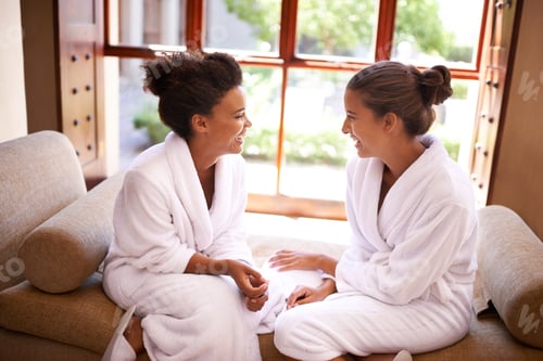 Preview: Chilling at the spa. Shot of two friends in bathrobes talking an laughing at a spa.