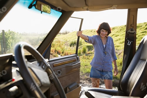 Preview: Young woman enjoying a road trip in a sunny countryside landscape.