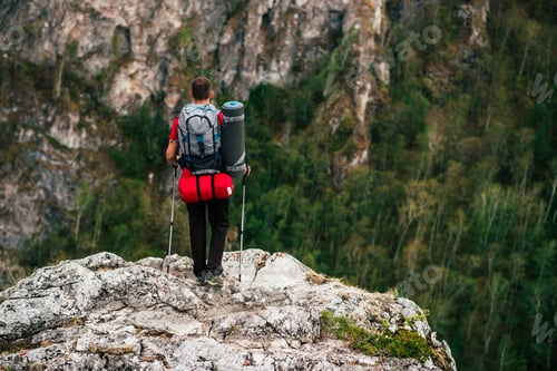 Preview: A traveler with a backpack in the mountains, rear view. The concept of a sporty lifestyle in travel