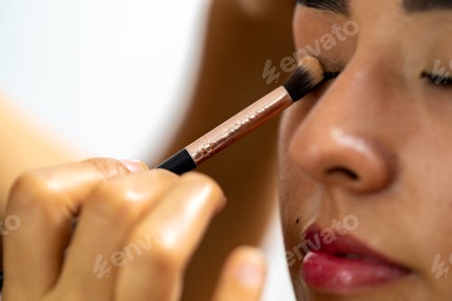 Preview: Applying professional makeup on young latina woman's eyelid