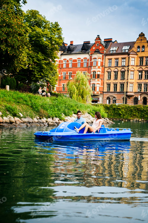 Preview: Friends enjoying pedal boating on river in city