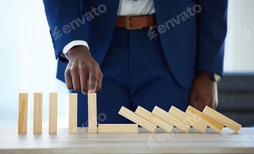 Preview: Shot of an unrecognisable businessman working with falling wooden blocks