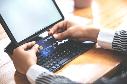 Preview: young woman holding credit card and using a laptop computer business woman working from home, online