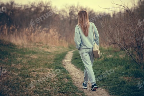Preview: beautiful young woman walking in the park