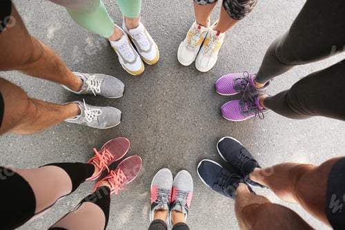 Preview: Young people making circle and showing their sports shoes outdoors, above view