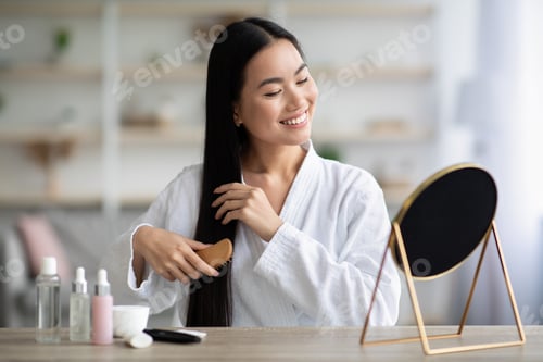 Preview: Woman in Robe Brushing Long Hair Indoors