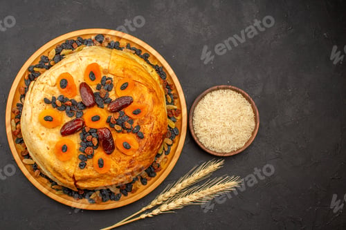Preview: top view shakh plov delicious rice meal cooked inside round dough with raisins on grey background