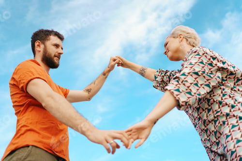 Preview: Loving Couple Holding Hands Outdoors on Sunny Day