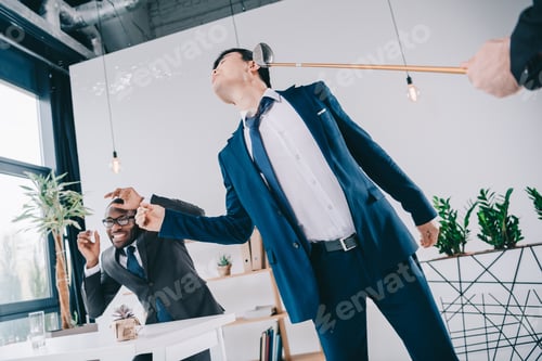Preview: young asian businessman get hit with golf cub