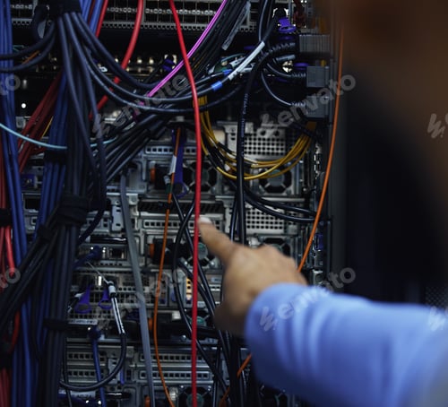 Preview: Cropped shot of an unrecognizable male IT support agent working in a dark network server room