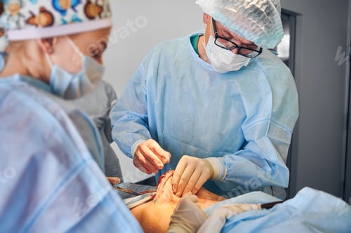 Preview: Medical workers doing abdominoplasty or tummy tuck surgery in clinic.