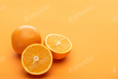 Preview: ripe delicious cut and whole oranges on colorful background