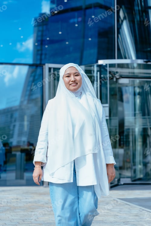 Woman in White Jacket Smiling Near Building
