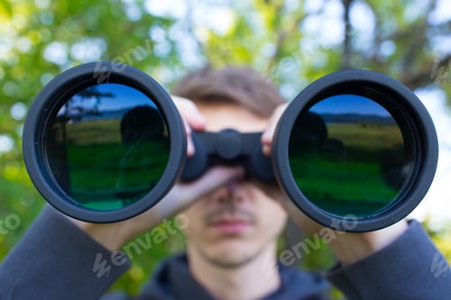 Preview: Young Man use of the binocular at forest
