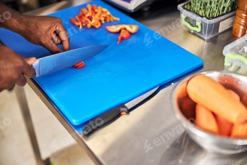 Preview: Man cutting vegetables in professional cafe kitchen