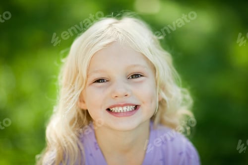 Preview: Young girl with a bright smile in a sunny park
