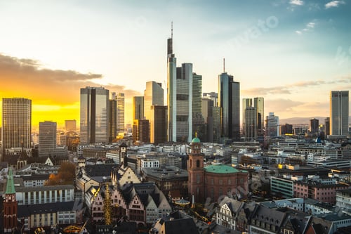 Preview: Frankfurt city surrounded by buildings under a cloudy sky during a golden sunset in Germany