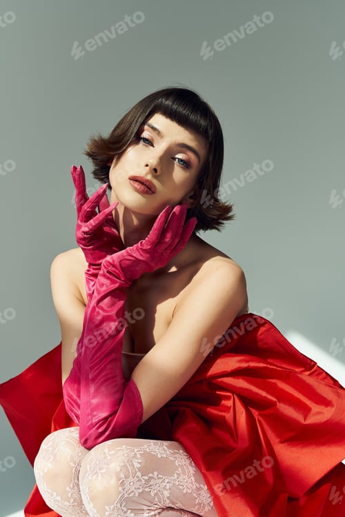 Preview: Young woman in a red dress with a large bow, exuding elegance and charm in a creative photoshoot