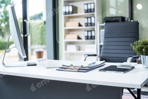 Preview: A desk in the office is neatly organized a computer monitor, document, tablet, telephone placed