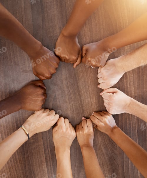 Preview: Hands, collaboration and motivation with the fists of a team in a circle or huddle on a wooden back
