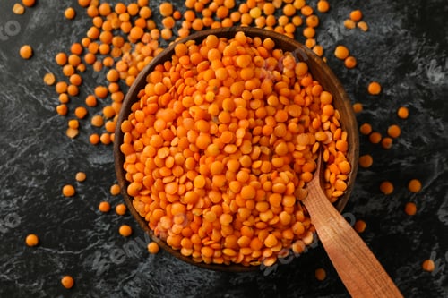 Preview: Bowl and spoon with red legumes on black smokey table
