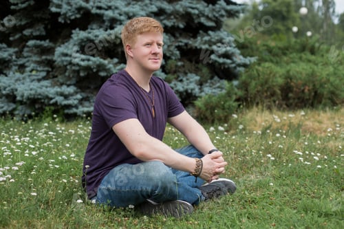 Preview: Man sits on the grass during lunch break