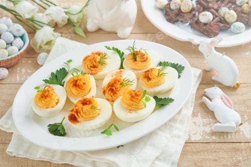 Preview: Easter stuffed eggs. Traditional Easter brunch or dinner with stuffed eggs with paprika, carrot cake
