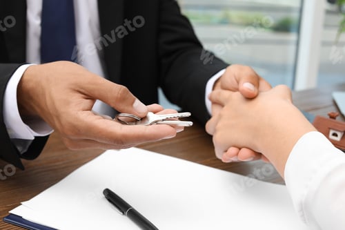 Preview: Real estate agent giving keys to woman at table