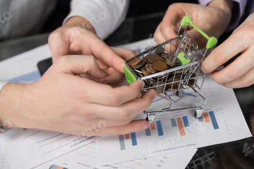 Preview: Men's hands pulled in different directions Dummy shopping cart filled with coins