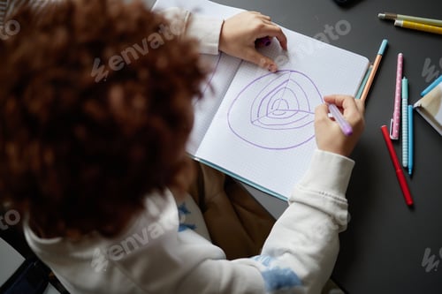 Preview: Child Drawing Layered Diagram of Planet in Notebook Using Colored Markers