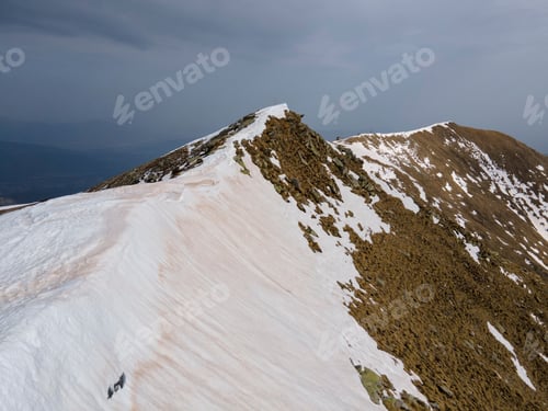 Preview: Snow-capped mountain top with a background of sky foggy mountains shadow.