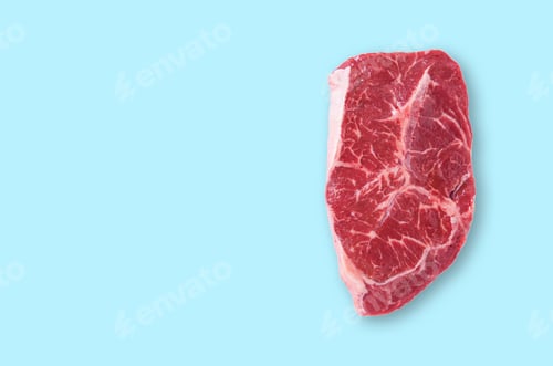 Preview: Fresh raw marble beef or pork steak ribeye on a blue isolated background.