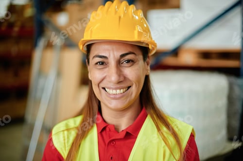 Preview: Portrait of a happy adult Caucasian working woman looking at the camera inside a warehouse
