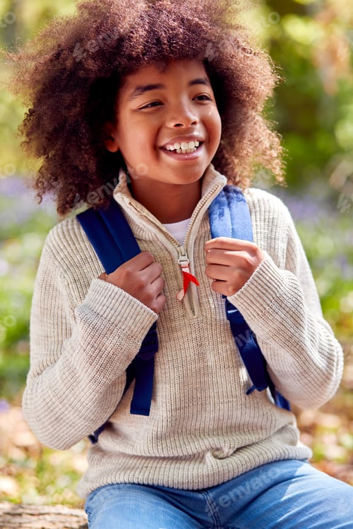 Preview: Portrait Of Boy Walking Through Bluebell Woods In Springtime Taking A Break Sitting On Log