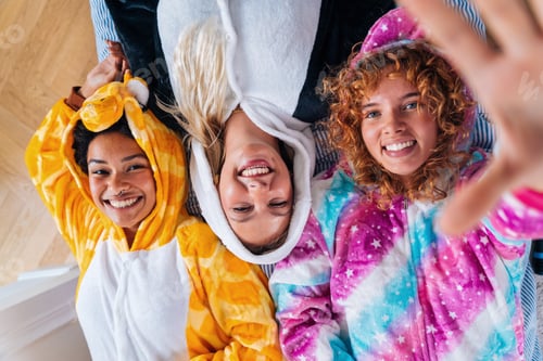 Preview: Multiethnic group of young female friends having pajamas party at home