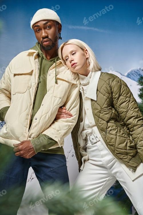 Preview: voguish pretty woman with her hand on her boyfriend arm looking dreamily away, diverse couple