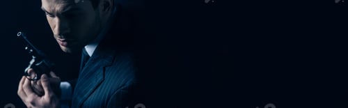 Preview: Gangster holding revolver on dark background, panoramic shot