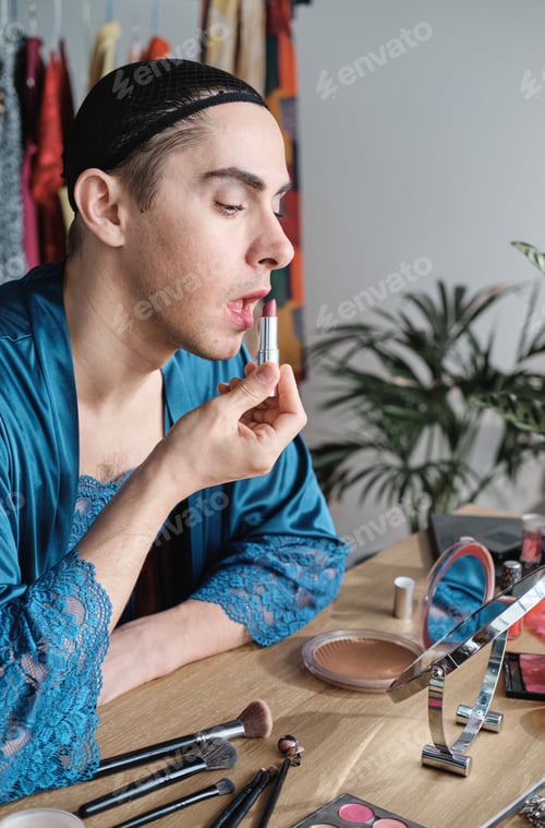 Preview: Man applying lipstick on his lips