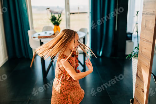 Preview: Little kid happy girl dancing on the kitchen at cozy home lifestyle authentic moment