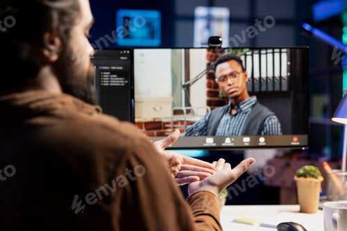 Preview: Engineer and colleague in remote videoconference writing code on PC