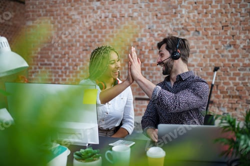 Preview: Cheerful young businesspeople sitting and working at desk in office, cooperation concept
