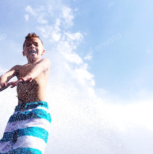 Preview: Child Enjoys Playing in Sprinkler on Sunny Day