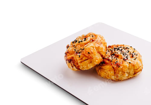 Preview: Delicious baked pastries topped with sesame seeds on a white platter