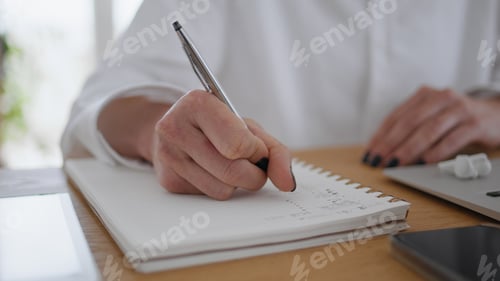 Preview: Woman hands writing in notebook wooden table closeup. Businesswoman making notes