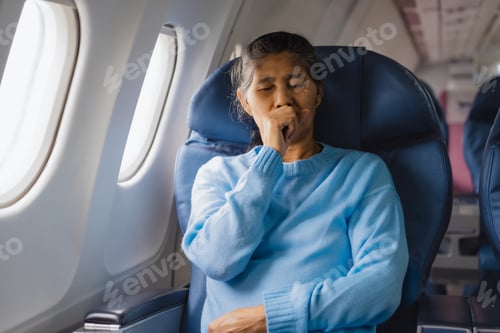 Preview: An elderly Asian woman sits inside an airplane, suffering from dizziness, nausea,sweating,paleness