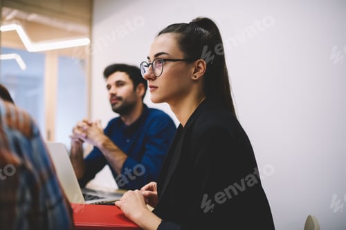 Preview: Pensive woman listening colleague while working