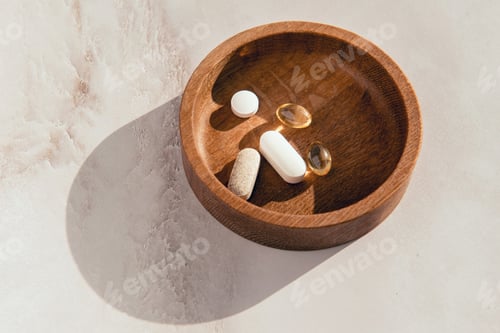 Preview: vitamins on a wooden plate - dietary supplement