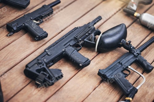 Preview: Paintball, gun and equipment on a wooden table or surface from above for sports, recreation or fun.