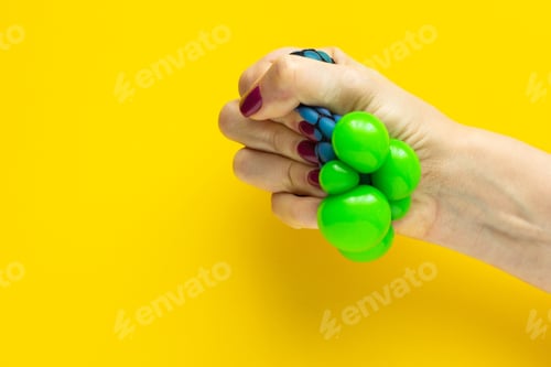 Preview: Toy anti-stress in a female hand on a yellow background